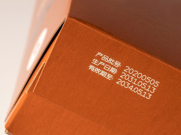 Linx CSL Laserbeschriftung Produktionsdaten auf beschichtetem Karton Schachtel Box mit Zahlen und chinesischen Schriftzeichen